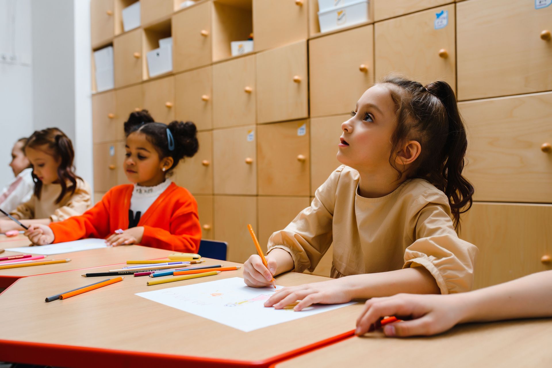Children participating in a creative classroom writing session indoors. Education and learning environment.